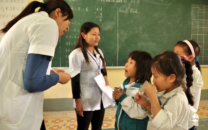 Cô giáo và học sinh trước bảng đen trong lớp học